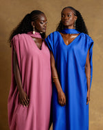 Load image into Gallery viewer, Two women wearing pink and blue dresses against a brown background