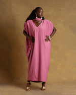 Load image into Gallery viewer, Woman wearing a pink dress against a brown background