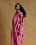 Load image into Gallery viewer, Woman wearing a pink dress against a brown background