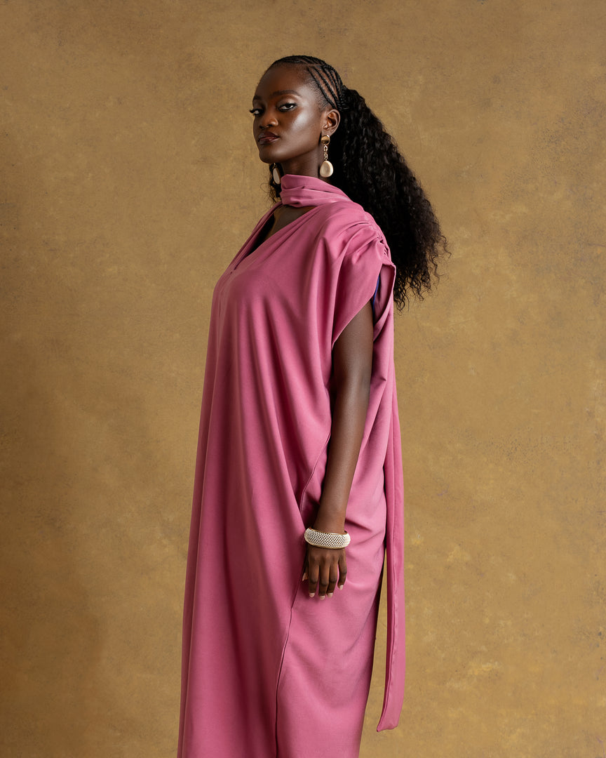 Woman wearing a pink dress against a brown background